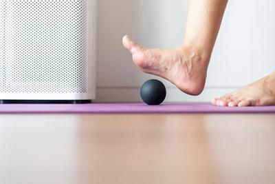 Massage for arch pain using a stress ball for foot