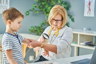 Doctor checking the skin and physical exam on young boy