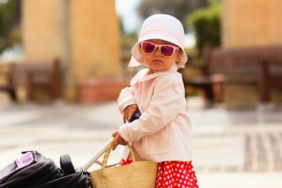 Young girl with sunglasses and bags for travel outdoor