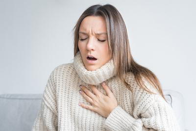 Woman holding her chest having an asthma attack.