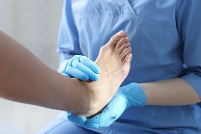 Foot and ankle specialist assessing painful ankle of patient