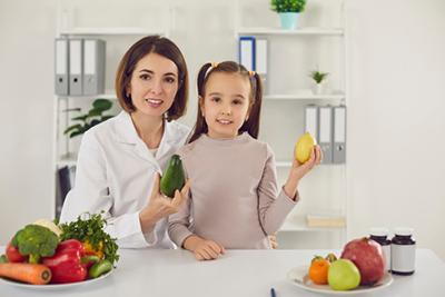 Little girl learning about healthy nutrition with her doctor