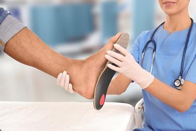Podiatrist-Holding-Patient's-Foot-wtih-Custom-Orthotics