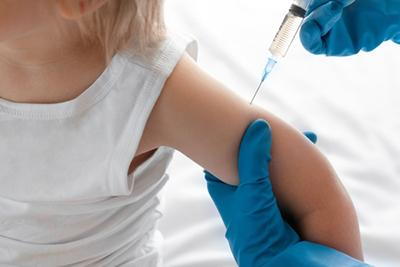 Pediatric nurse administering vaccine to a child in clinic.