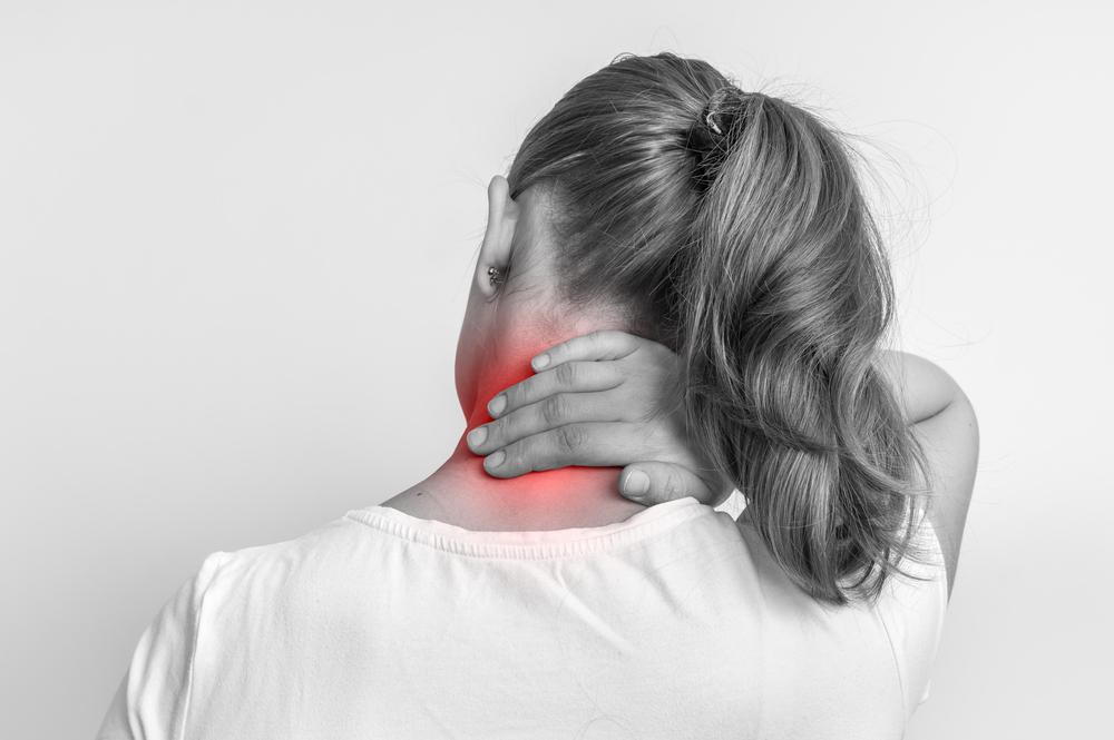 woman holding her neck because of neck pain