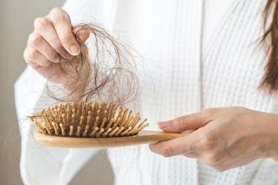Woman removing hair from comb with her hand