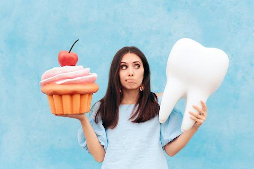 woman holding big cupcake and big tooth