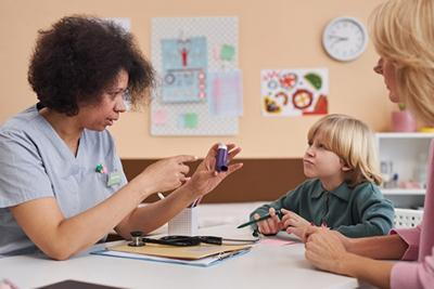 Clinic setting with pediatrician, child, and parent discussing asthma management tools