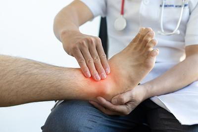 Man suffering from ankle injury checked by the doctor