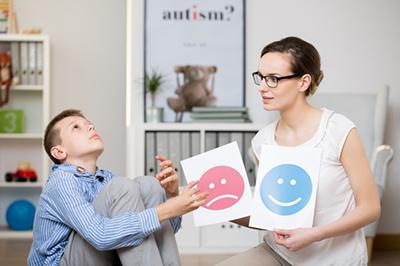 Therapist teaching an autistic child in study room