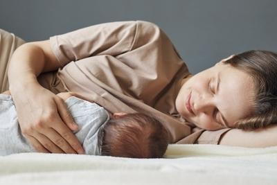 Mother Breastfeeding her baby on bed