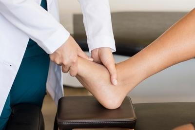 Doctor assessing patient’s ankle and foot during foot care visit