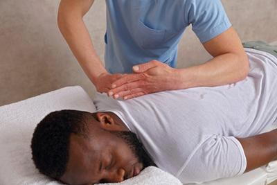 Chiropractor treating man's back for spinal alignment