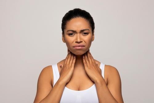 Female patient holding neck with swollen tonsils