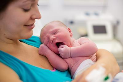 Woman-with-her-newborn-smiling-to-the-baby.