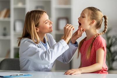 Young girl suffering from sore throat check by the doctor