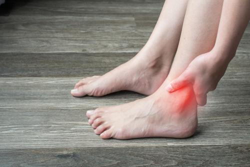 Woman experiencing ankle arthritis at home