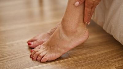 Older adult touching foot showing pain linked to aging and foot health