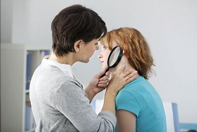 Doctor checking the skin condition of woman patient