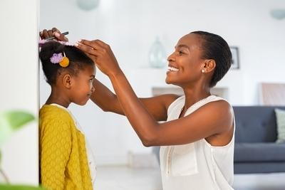 Mother measuring her child on wall with a smile