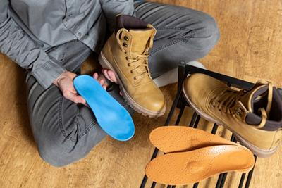 Man-is-About-to-Insert-His-Custom-Orthotics-into-His-Shoes
