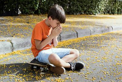 Young boy holding his nose with sneezing