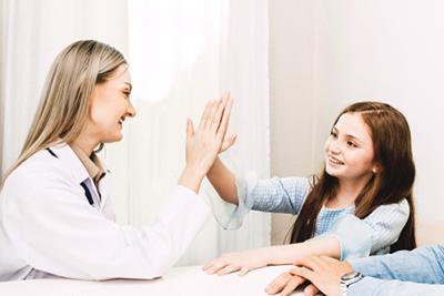 Pediatrician examining little girl during health visit