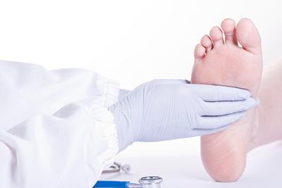 Doctor holding the patient foot on clinic.