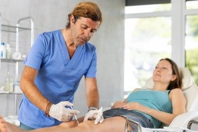 Doctor injecting on patient foot as a treatment.