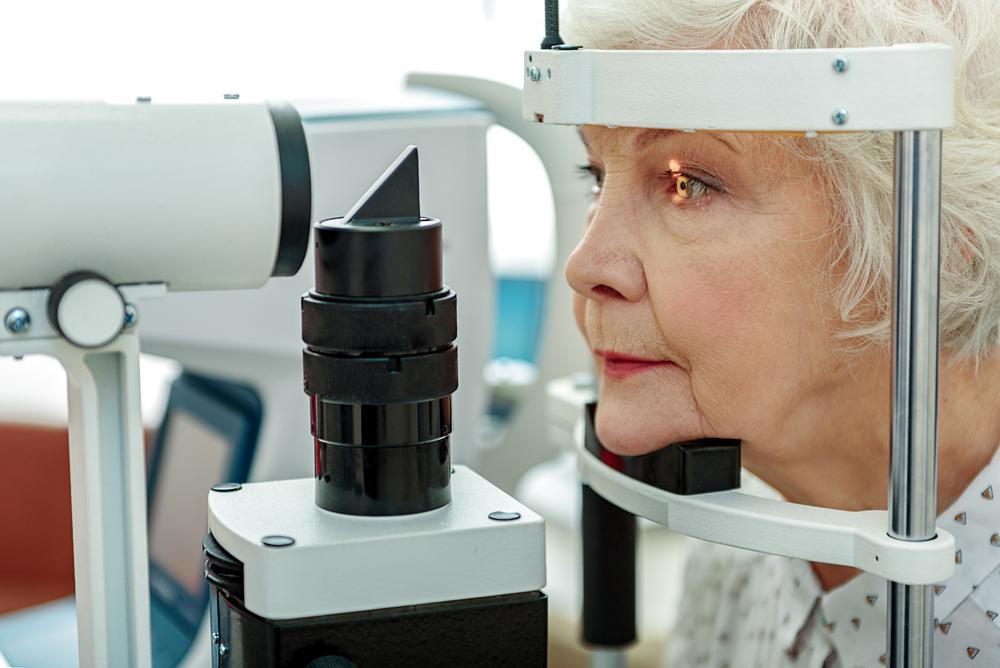 senior citizen receiving an eye exam from her optometrist