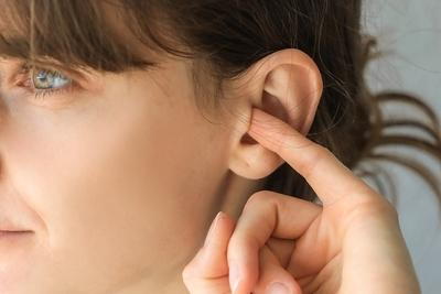 Young-woman-insert-her-finger-in-the-ear-hole.