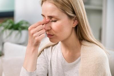 A woman pressing her nose bridge due to sinus pressure
