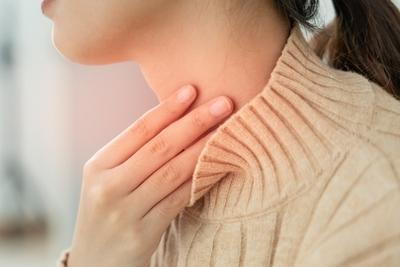 Woman suffering from Thyroid Pain in red