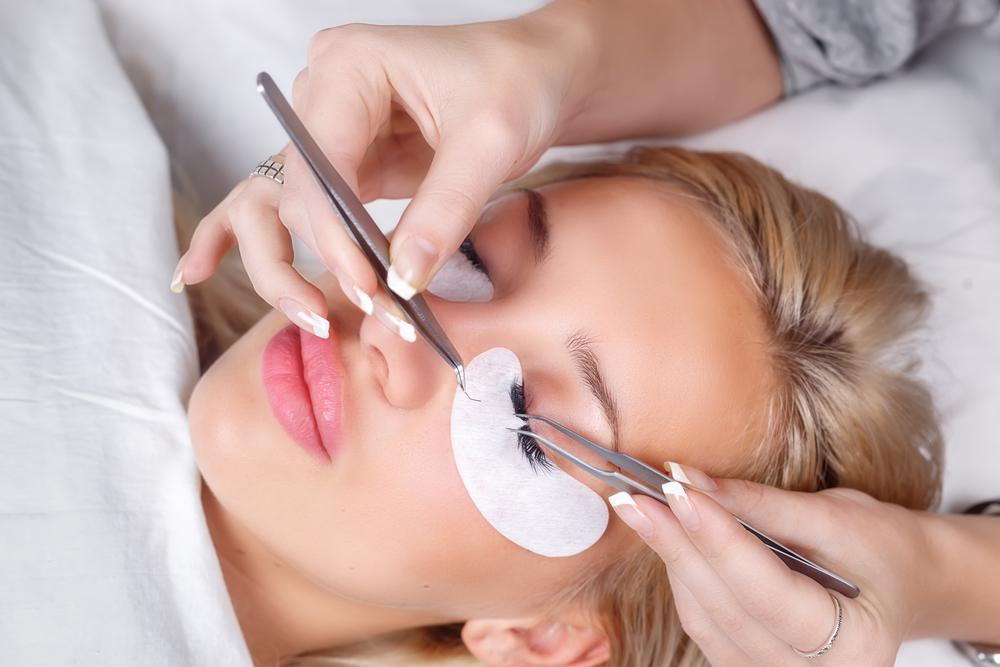 woman getting eyelash extensions at salon