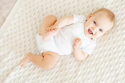 Smiling baby on the bed.