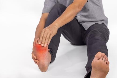 Person suffering from arthritis on foot in red