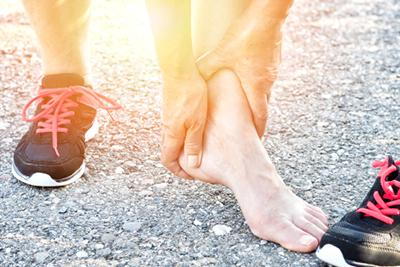 Runner suffering from heel pain outdoor.