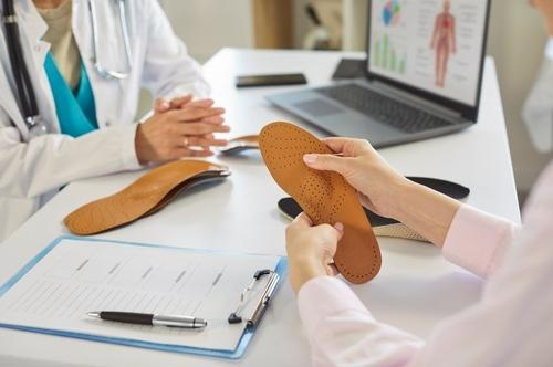 A podiatrist explaining custom orthotic options to a patient.