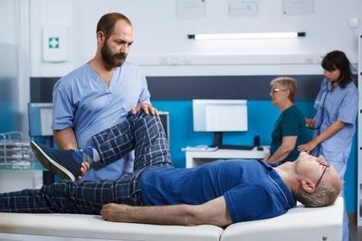 Therapist holding the one foot of patient and check it.