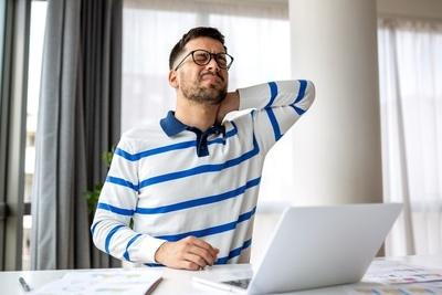 Man having a backpain infront of the computer