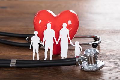 Stethoscope wrapped around a heart with a family cutout, representing holistic medical care.