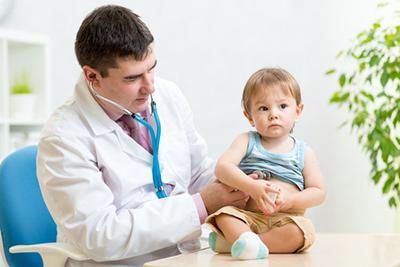 Doctor checking the toddler on clinic table