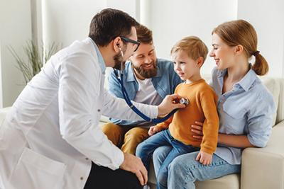 Family medicine doctor examining a child while the parent observes