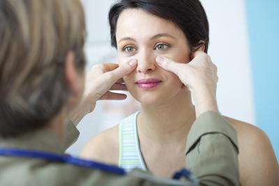 Doctor checking the sinus of a woman patient