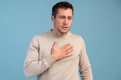 Man suffering from chest pain holding his chest