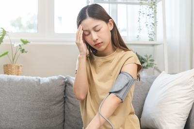 Woman suffering from low blood pressure with stethoscope on her hand.