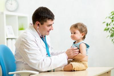 Doctor checking the little boy on clinic with stesthoscope