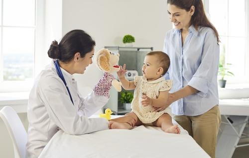 Mother holding her baby during a pediatric visit for newborn care.