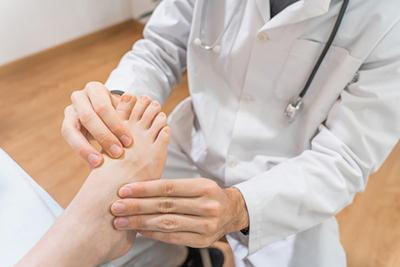 Doctor holding the foot of patient and check.