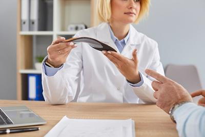 Doctor recommending the foot orthotics on patient